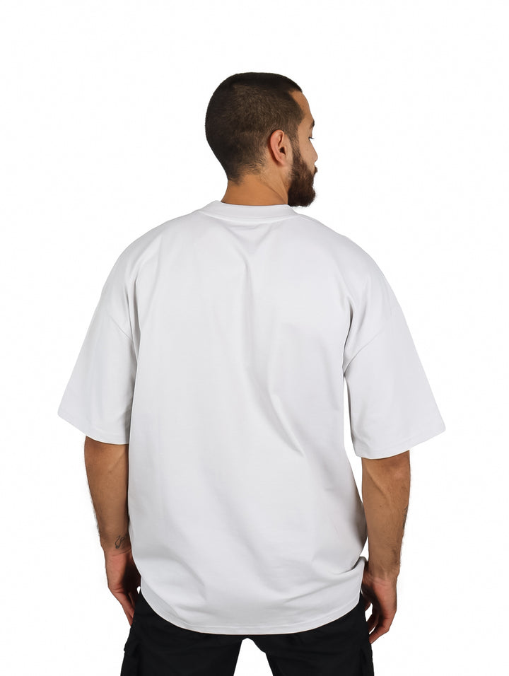 Hombre vistiendo playera oversize de color gris con cuello redondo y manga corta.