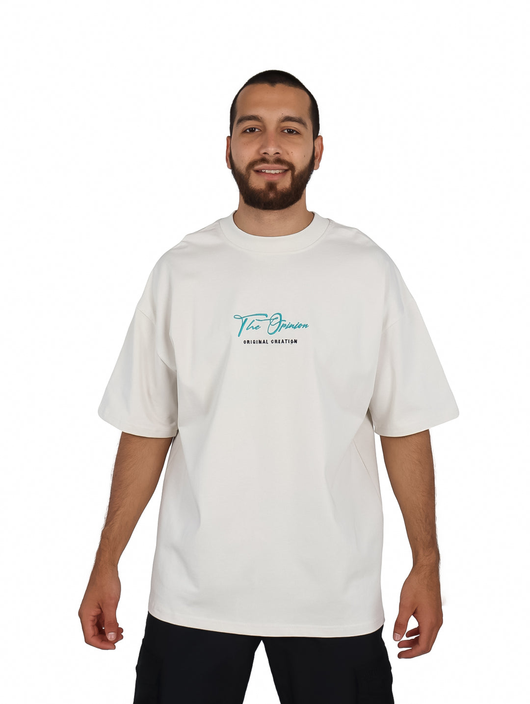 Hombre vistiendo playera oversize color beige con logotipo pequeño en el pecho.