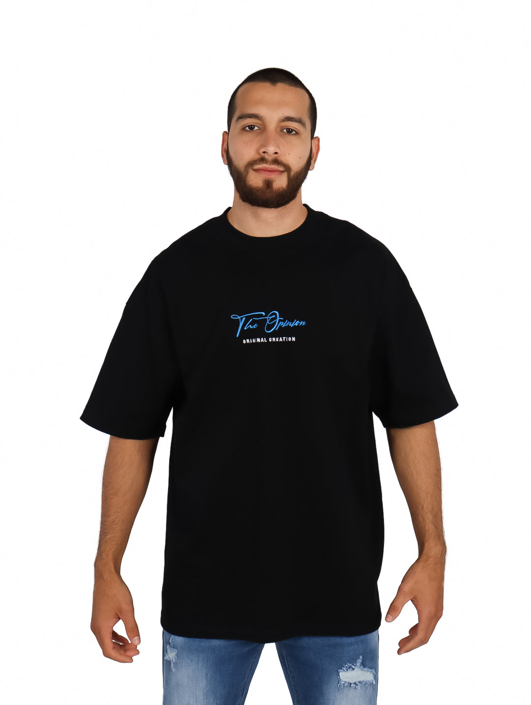 Hombre vistiendo playera oversize color negro con logo azul en el pecho.