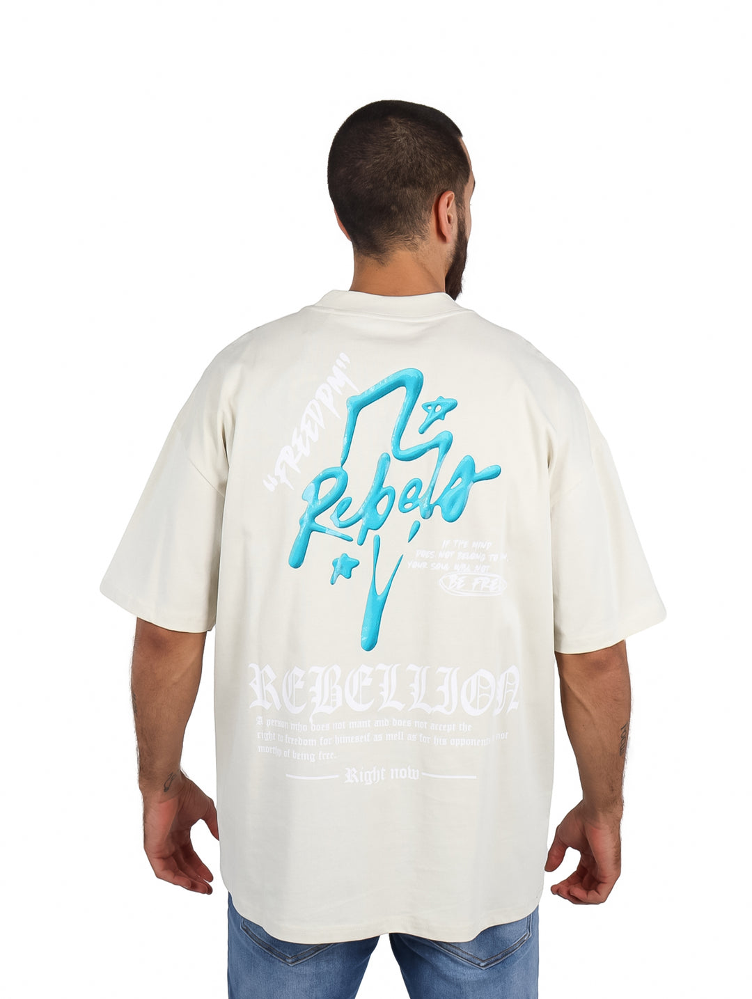 Hombre vistiendo playera oversize color arena con logo azul en el pecho.