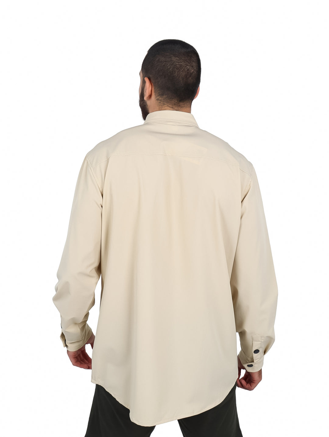 Hombre vistiendo camisa oversize color khaki de manga larga con bolsillos frontales y botones negros.