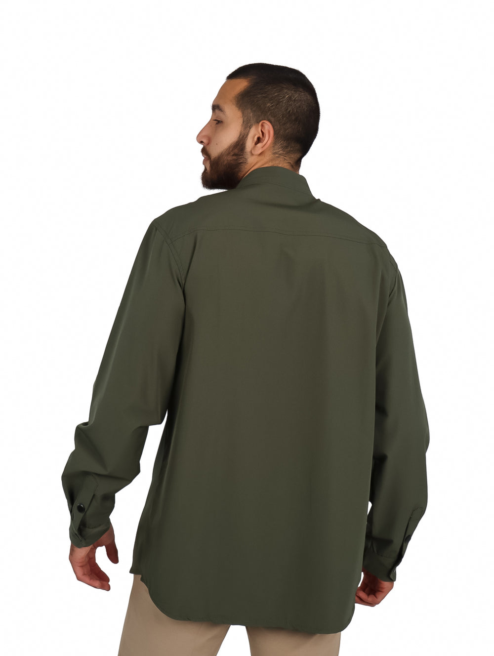 Hombre vistiendo camisa oversize color verde oliva con bolsillos frontales y manga larga.