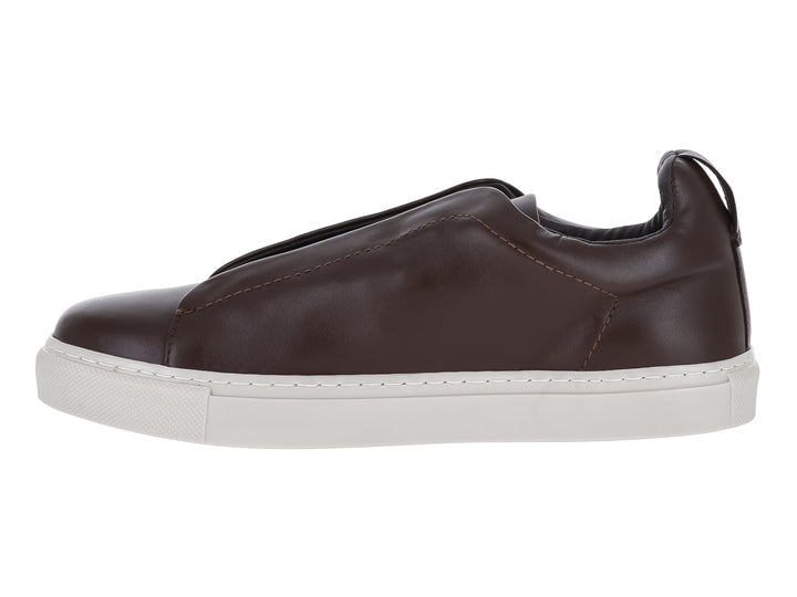Zapato casual slip-on de cuero color café con suela blanca plana.