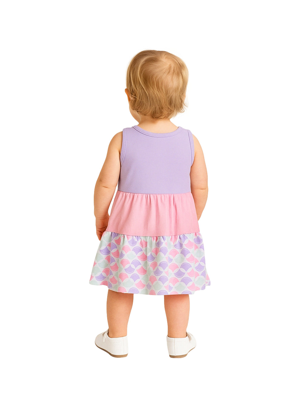 Niña pequeña con vestido casual en tonos lila y rosa con estampado de escamas en el borde inferior.