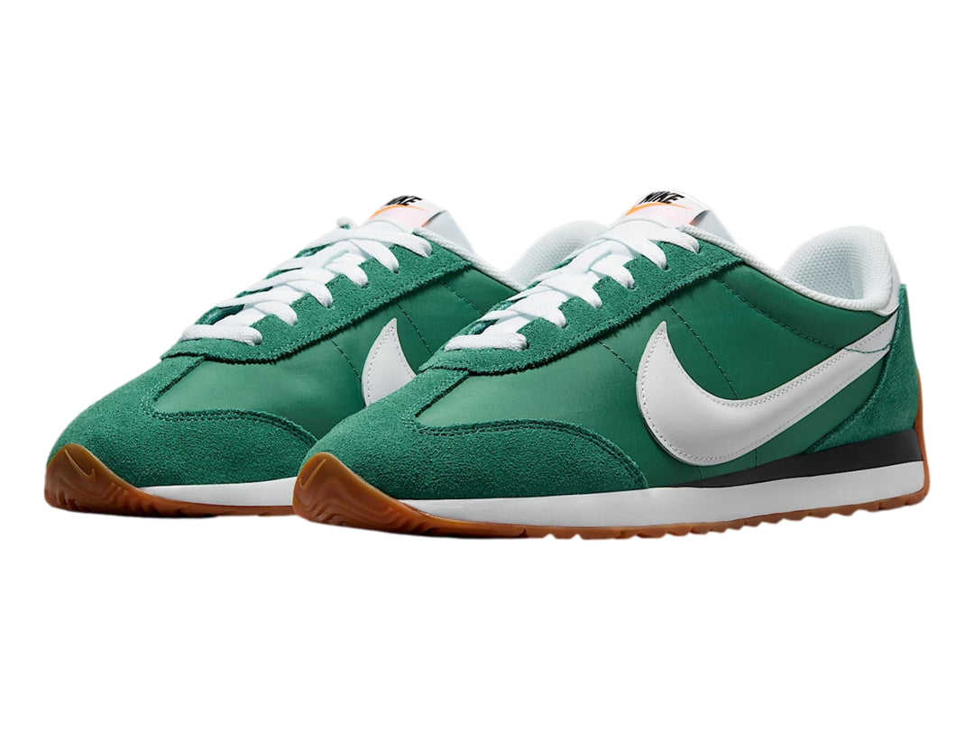 Tenis Nike color verde Evergreen Aura con suela color goma y detalles en blanco y negro.