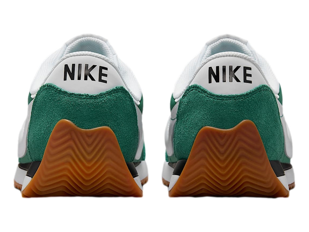 Tenis Nike color verde Evergreen Aura con suela color goma y detalles en blanco y negro.