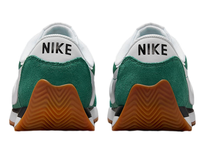 Tenis Nike color verde Evergreen Aura con suela color goma y detalles en blanco y negro.
