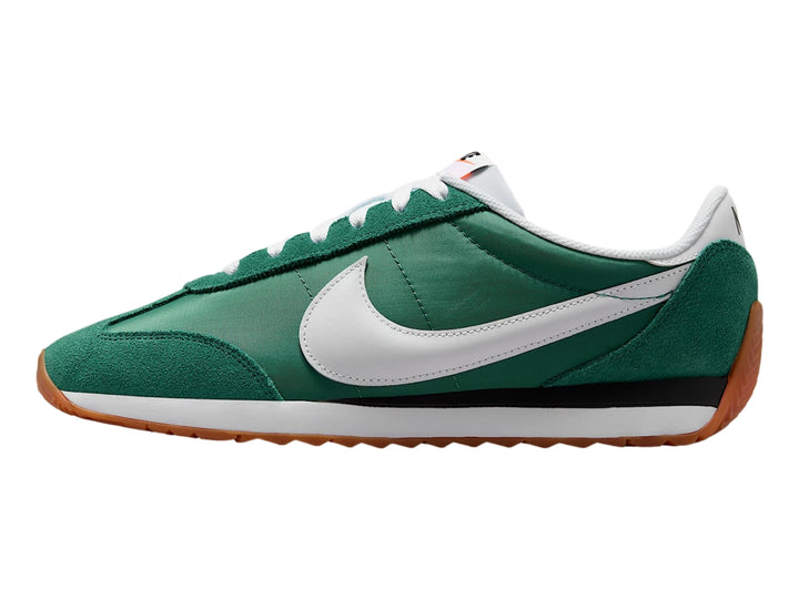 Tenis Nike color verde Evergreen Aura con suela color goma y detalles en blanco y negro.
