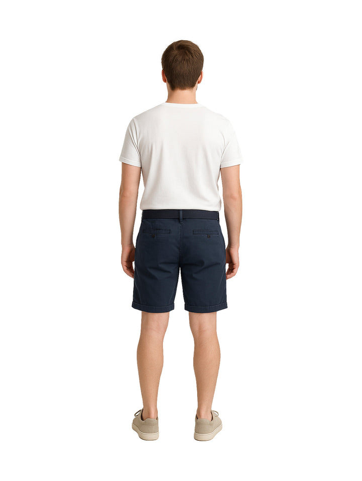 Hombre vistiendo bermudas color azul marino con cinturón a juego y camiseta blanca.