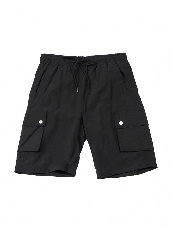 Hombre vistiendo shorts de surf color negro con bolsillos laterales.