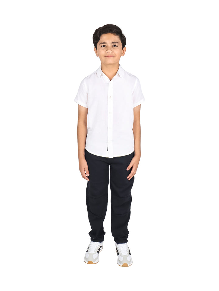 Niño vistiendo una camisa de lino color blanco de manga corta y cuello clásico.
