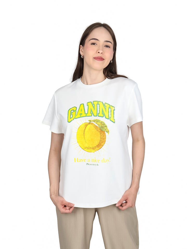 Mujer vistiendo playera blanca de manga corta con estampado amarillo de un durazno y texto.