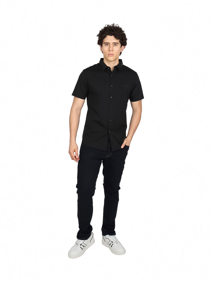 Hombre vistiendo una camisa de manga corta color negro con cuello y botones frontales.