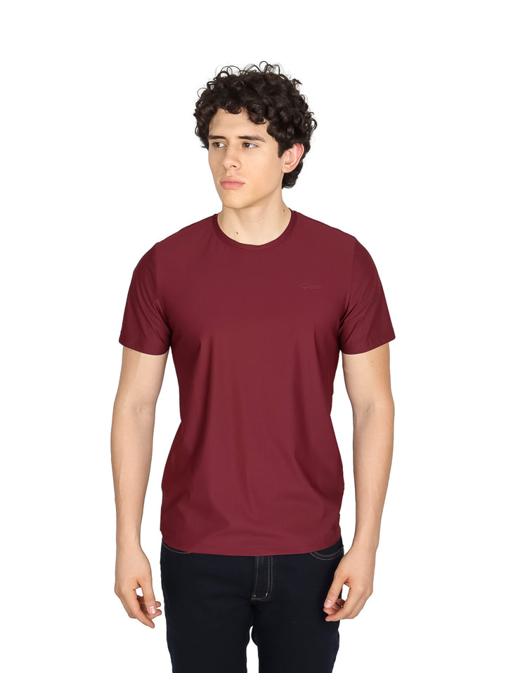 Hombre vistiendo una playera básica de manga corta en color vino con cuello redondo.