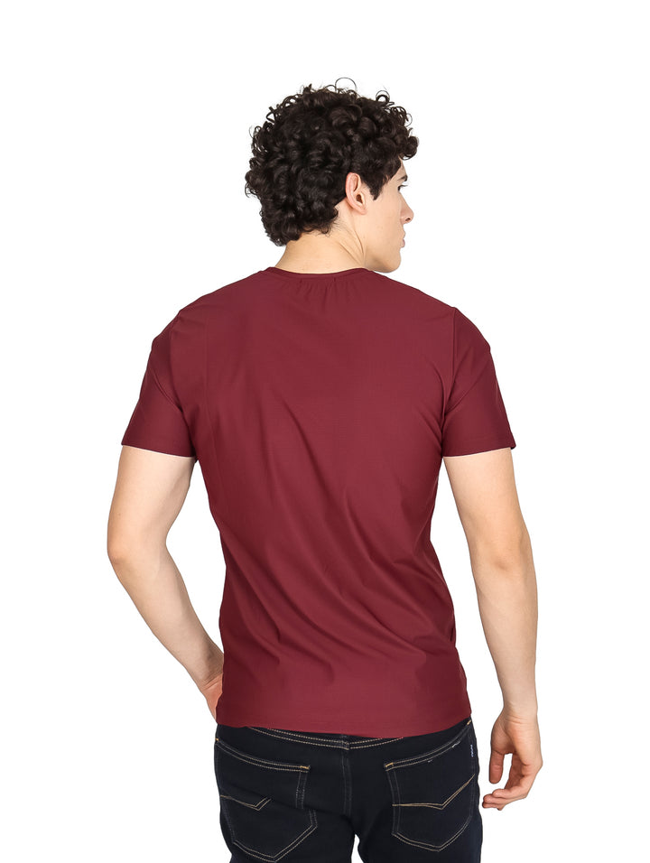 Hombre vistiendo una playera básica de manga corta en color vino con cuello redondo.
