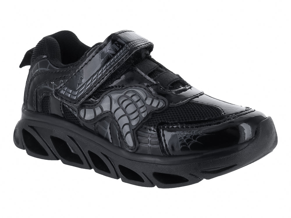 Tenis deportivos negros para niño con diseño de hueso en el lateral y cierre de velcro.