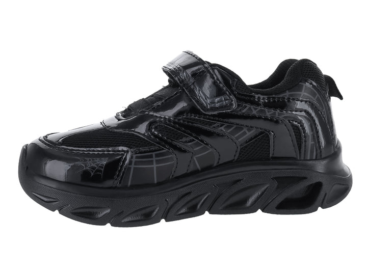 Tenis deportivos negros para niño con diseño de hueso en el lateral y cierre de velcro.