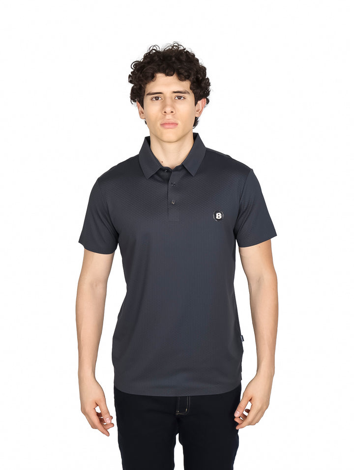 Hombre vistiendo una playera polo de color gris oscuro con cuello y manga corta.