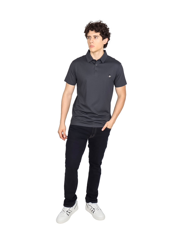 Hombre vistiendo una playera polo de color gris oscuro con cuello y manga corta.