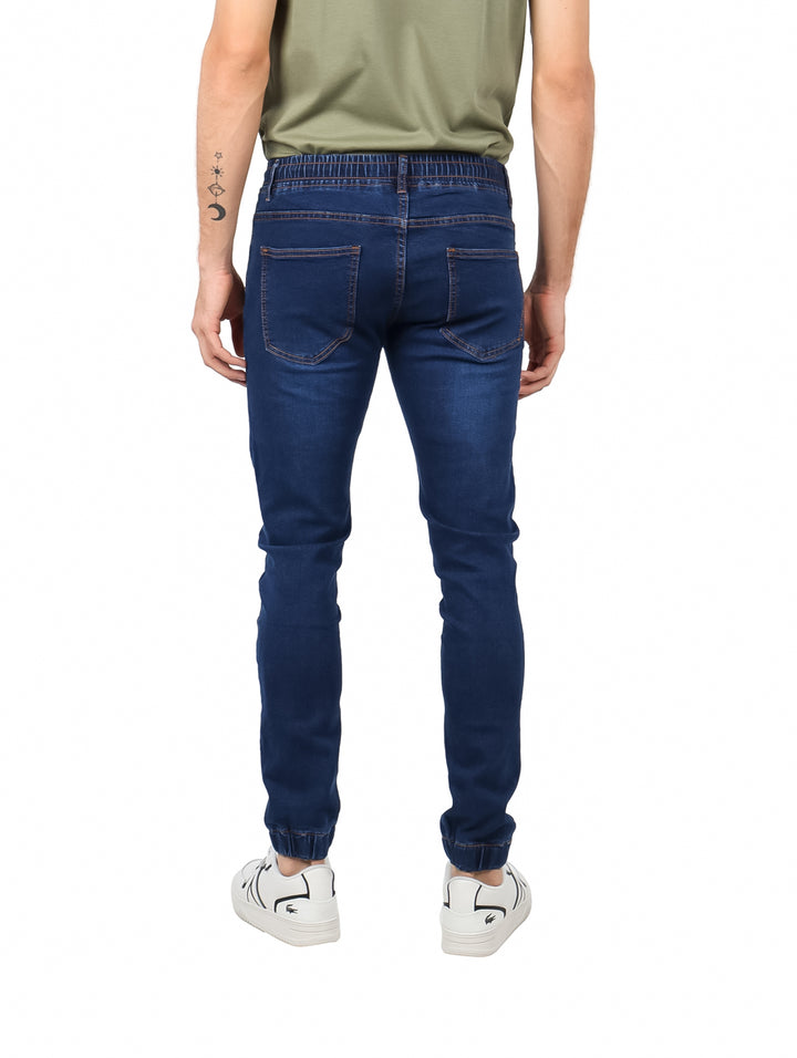 Hombre vistiendo jeans jogger color índigo con cintura elástica y cordón rojo.