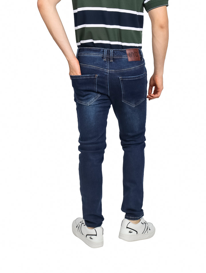 Hombre vistiendo pantalones jeans skinny fit en color indigo con efecto deslavado.