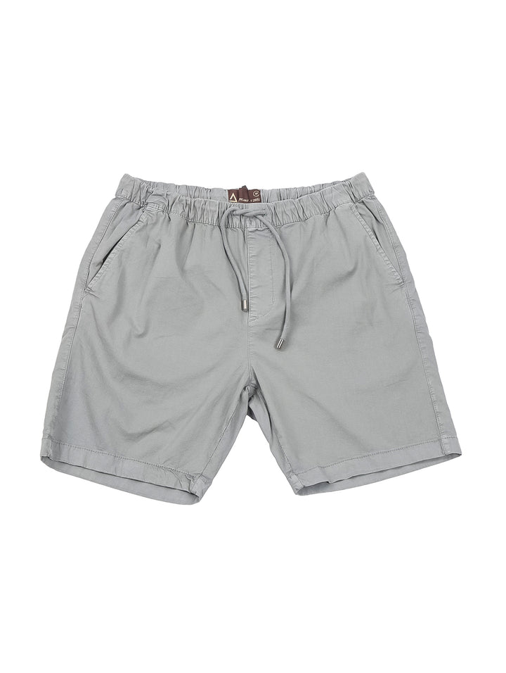 Hombre vistiendo bermudas color gris claro con cintura elástica y cordón.