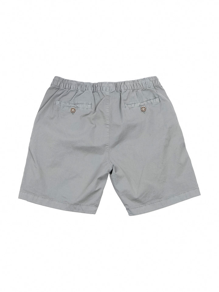 Hombre vistiendo bermudas color gris claro con cintura elástica y cordón.