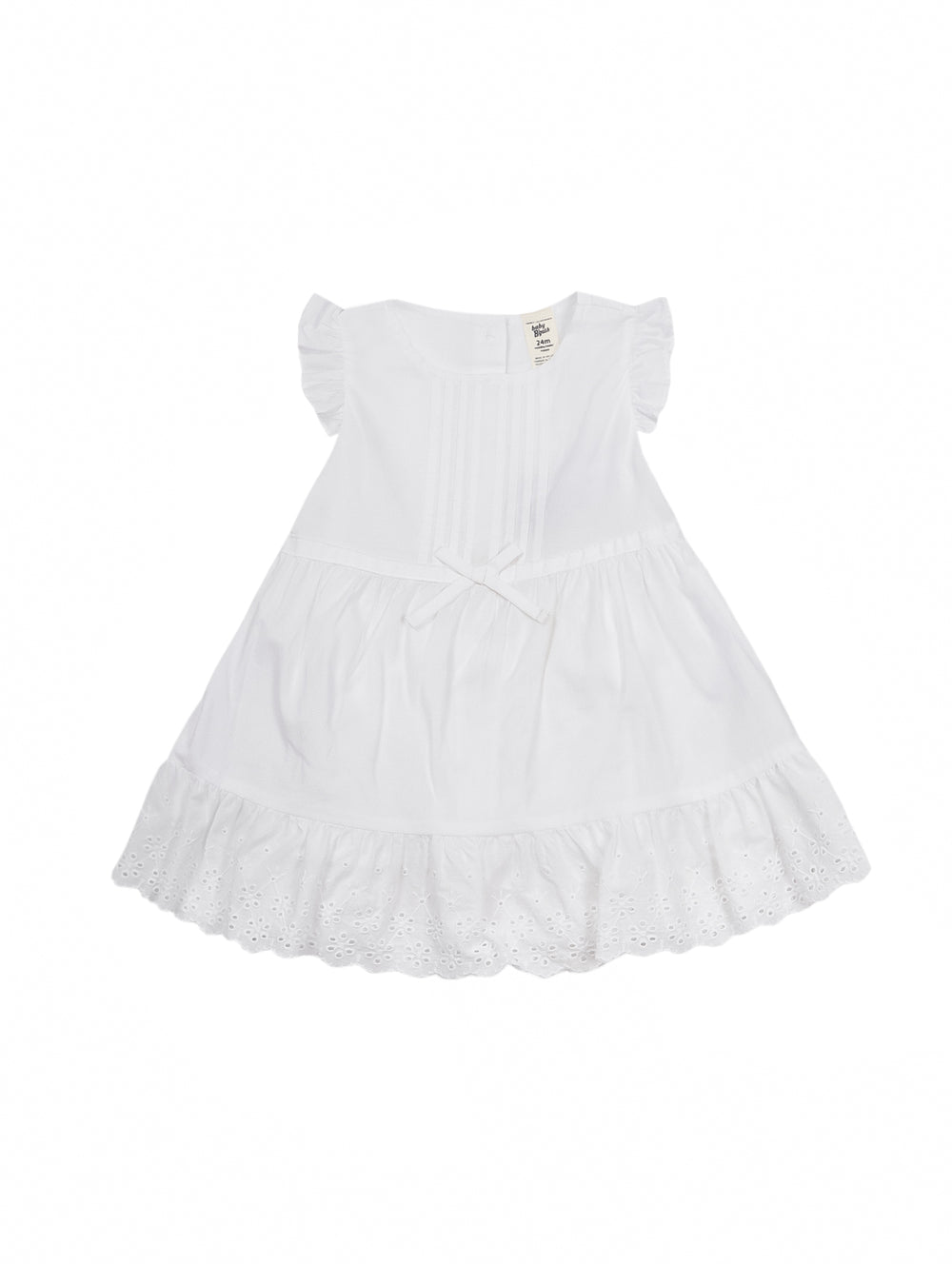 Niña pequeña vistiendo un vestido blanco sin mangas con moño en la cintura y detalles de encaje en el borde inferior.
