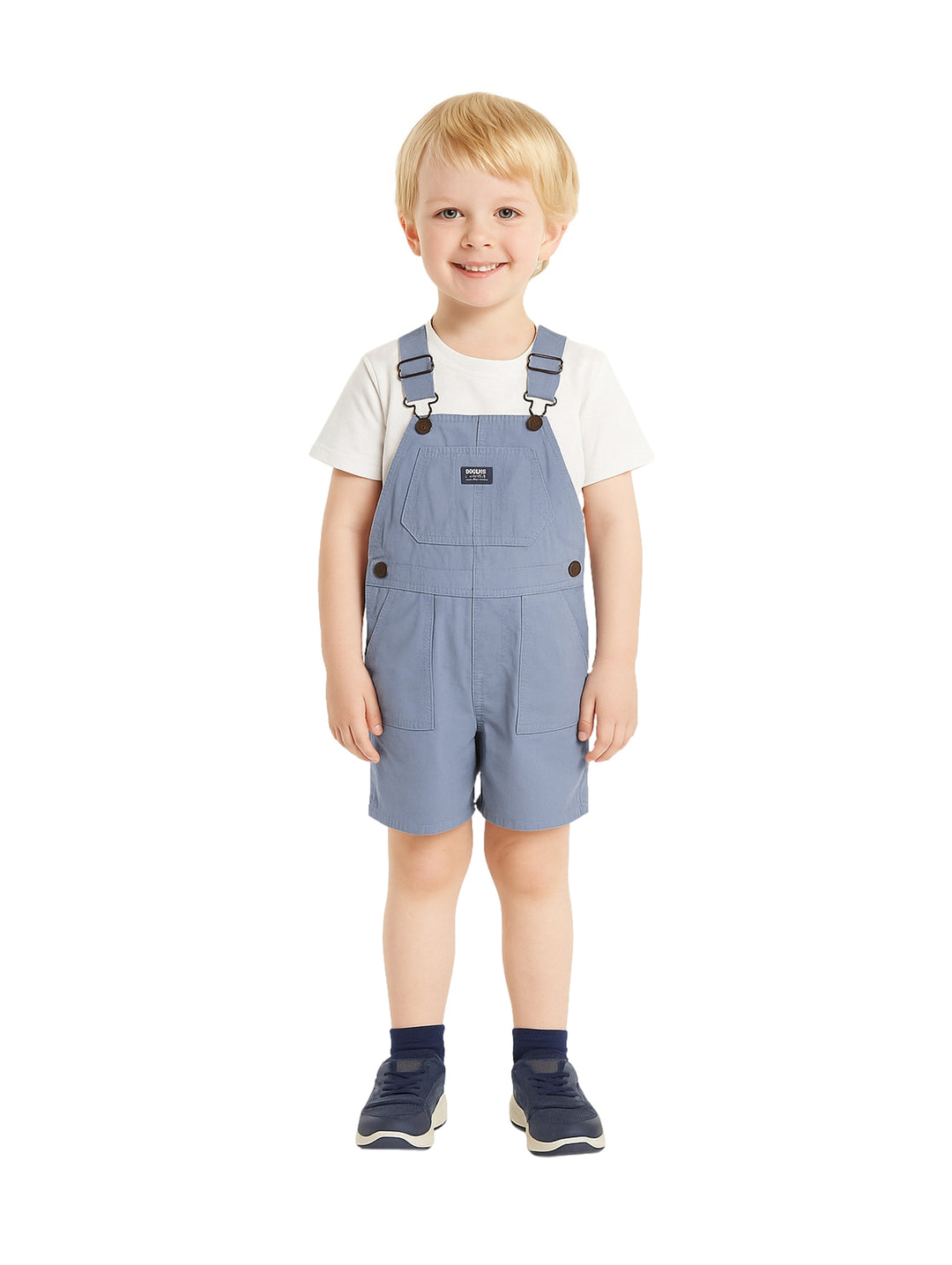 Niño vistiendo un overol corto color azul con tirantes y una camiseta blanca.
