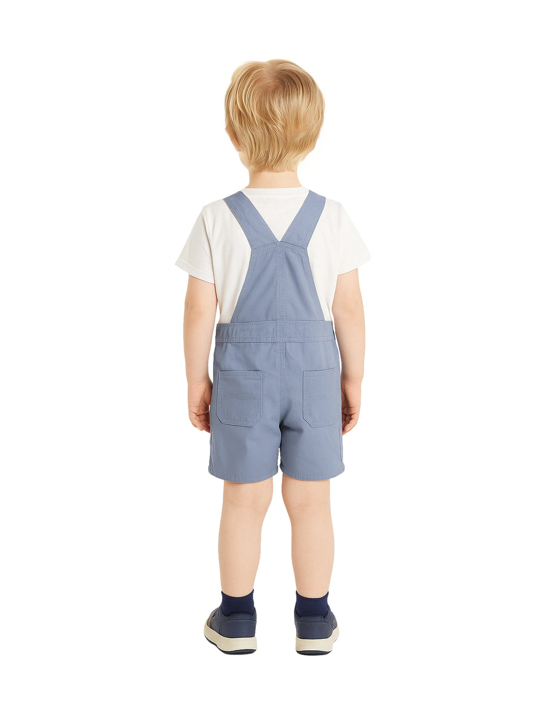 Niño vistiendo un overol corto color azul con tirantes y una camiseta blanca.