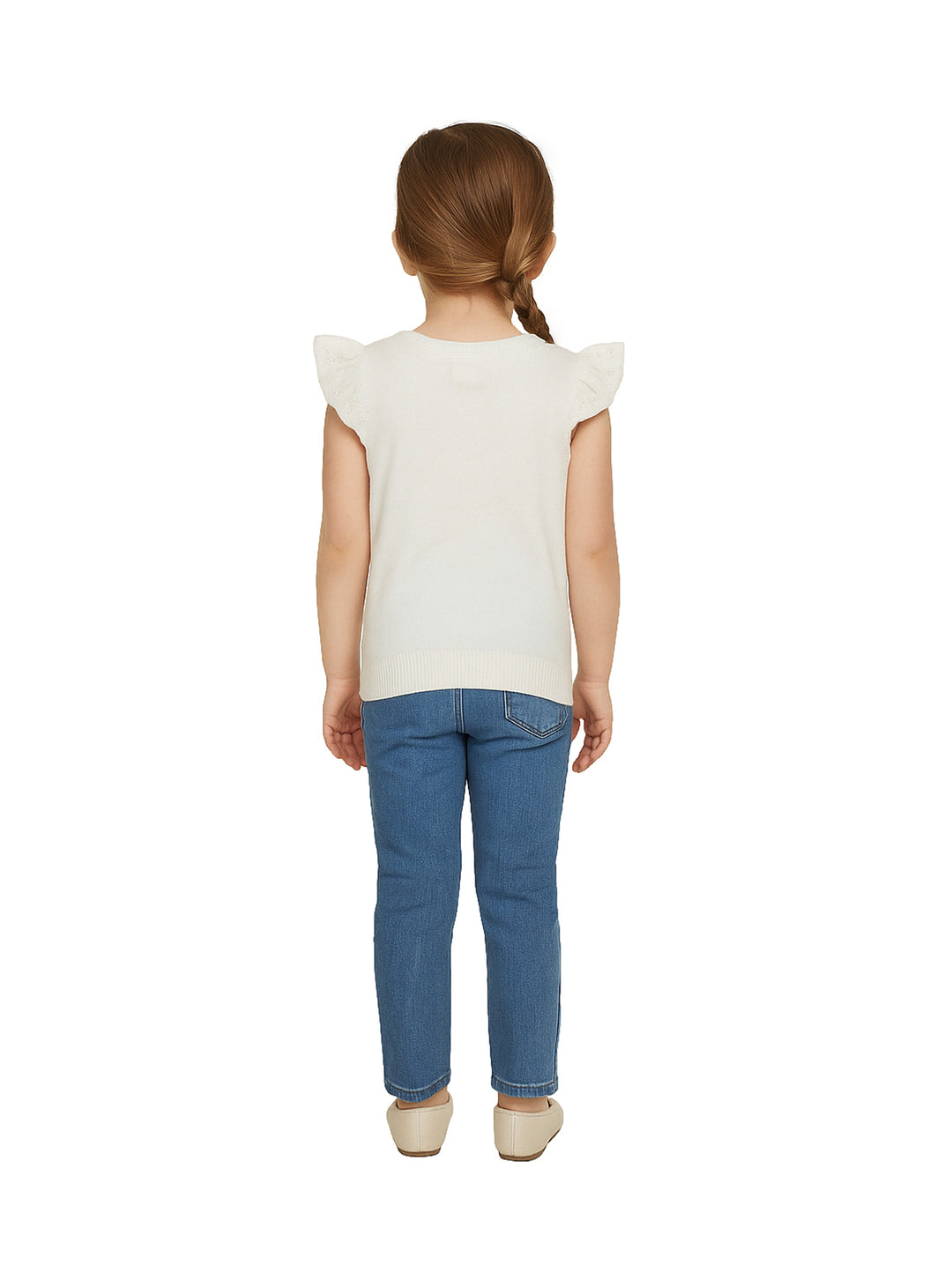 Niña vistiendo una blusa blanca de manga corta con volantes y pantalones azules.