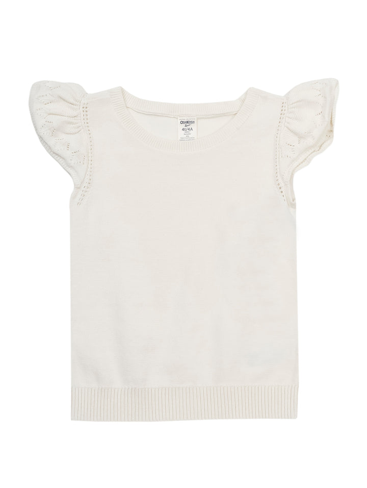 Niña vistiendo una blusa blanca de manga corta con volantes y pantalones azules.