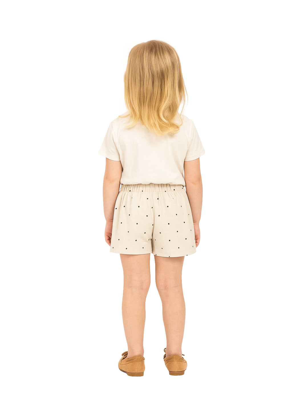 Niña vistiendo un short falda color beige con lunares oscuros y un lazo en la cintura.