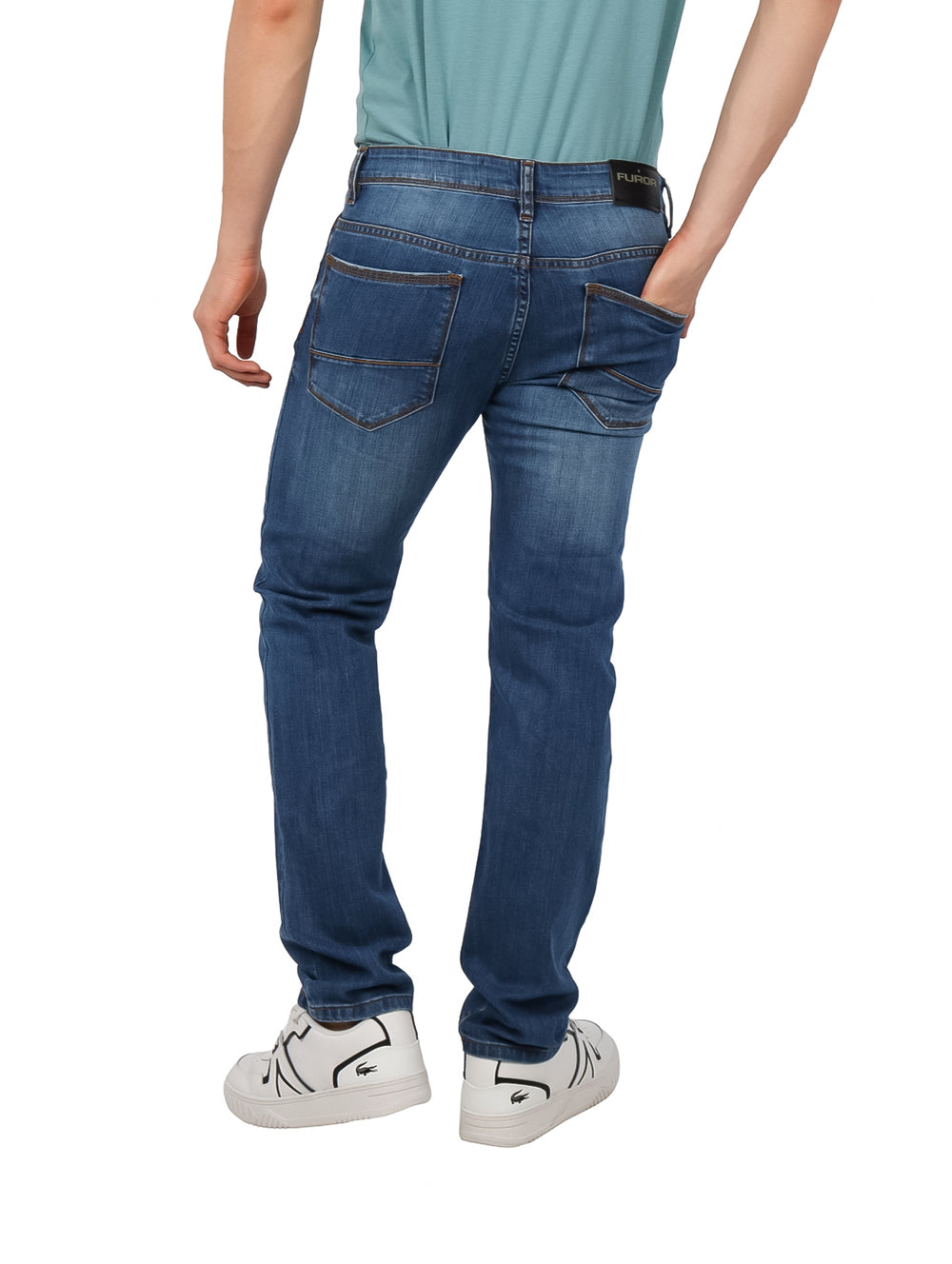 Hombre vistiendo pantalones jeans color azul con efecto lavado stone wash.