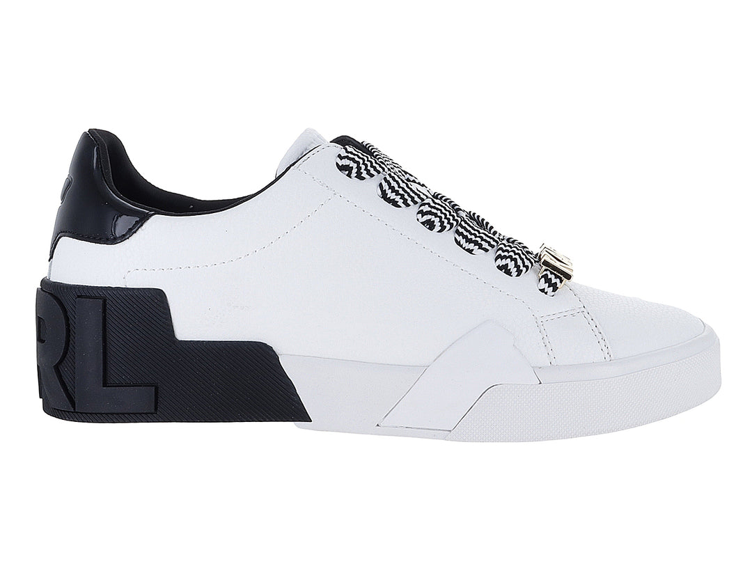 Tenis blancos de cuero con talón negro brillante y cordones a rayas blancas y negras.