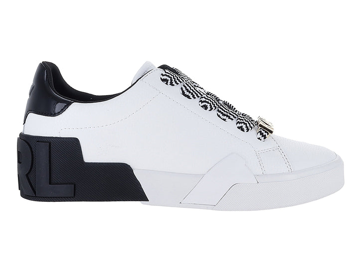 Tenis blancos de cuero con talón negro brillante y cordones a rayas blancas y negras.