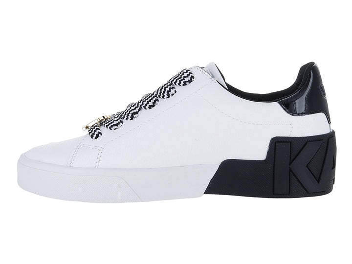 Tenis blancos de cuero con talón negro brillante y cordones a rayas blancas y negras.