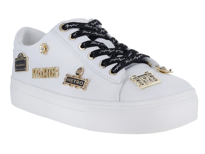 Tenis blancos Karl Lagerfeld con agujetas negras y pines decorativos dorados con la palabra Paris.
