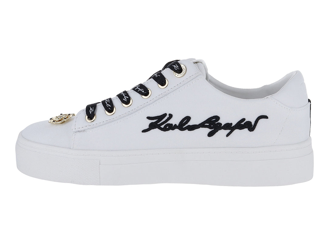 Tenis blancos Karl Lagerfeld con agujetas negras y pines decorativos dorados con la palabra Paris.
