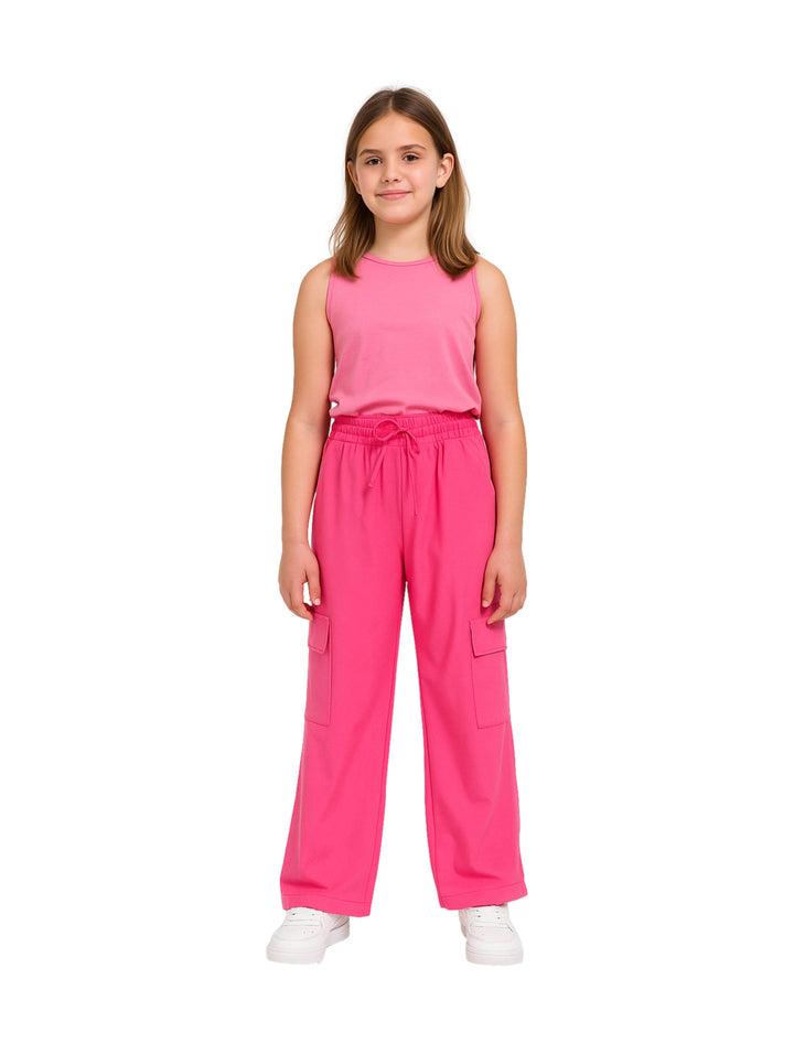 Niña vistiendo pantalón fucsia de pierna ancha con bolsillos laterales y cintura elástica sobre fondo blanco.