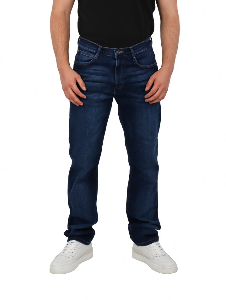 Hombre vistiendo pantalones jeans Lee color índigo de corte recto.
