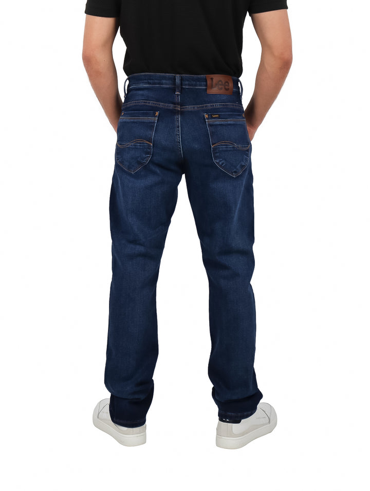 Hombre vistiendo pantalones jeans Lee color índigo de corte recto.