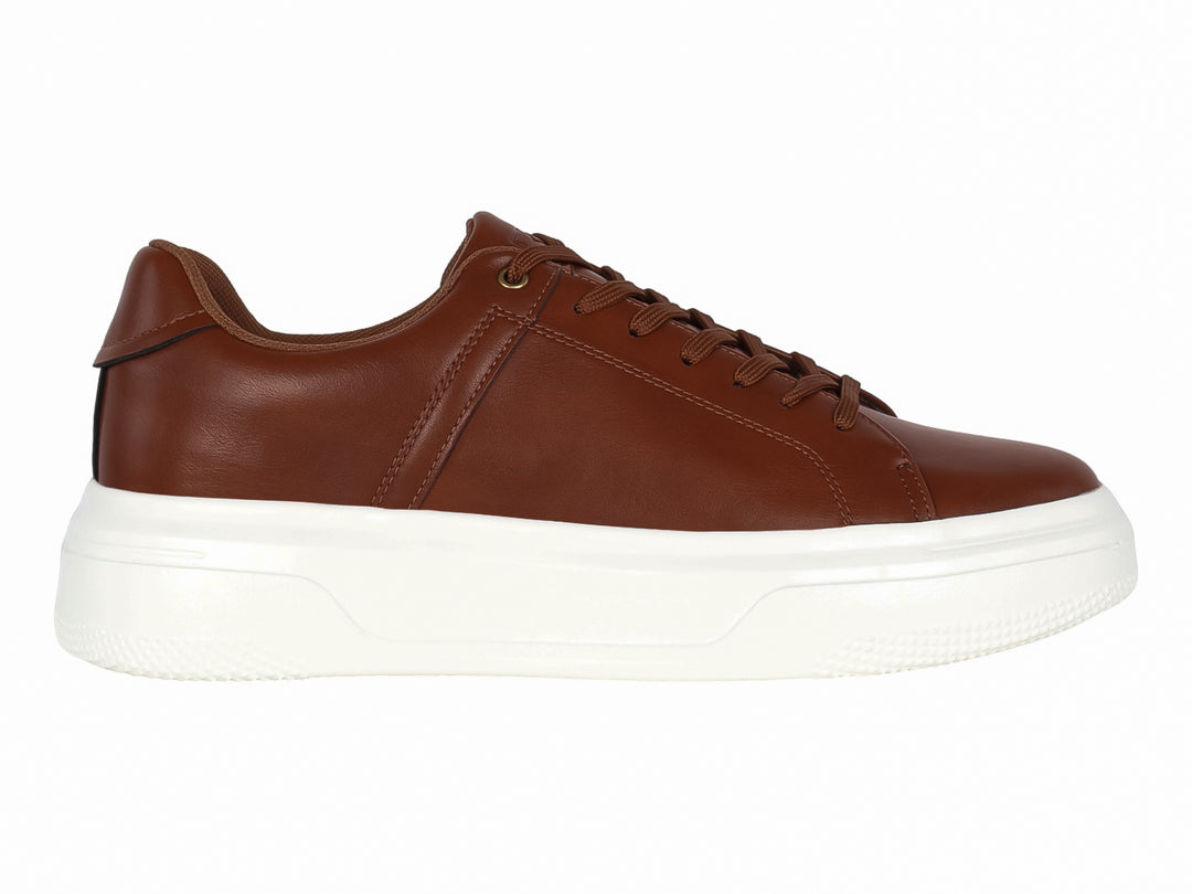 Tenis casuales color café con suela blanca de plataforma.