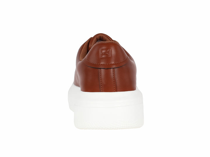 Tenis casuales color café con suela blanca de plataforma.