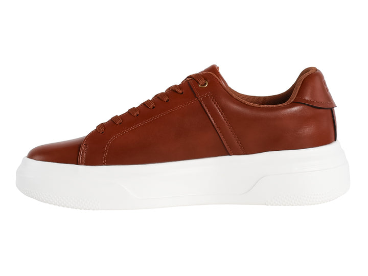 Tenis casuales color café con suela blanca de plataforma.