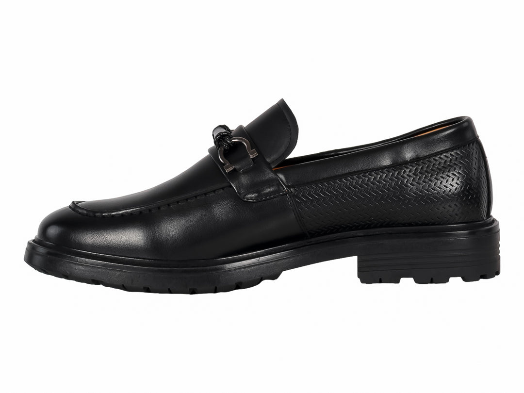 Zapato mocasín negro para hombre con hebilla metálica y suela gruesa dentada.