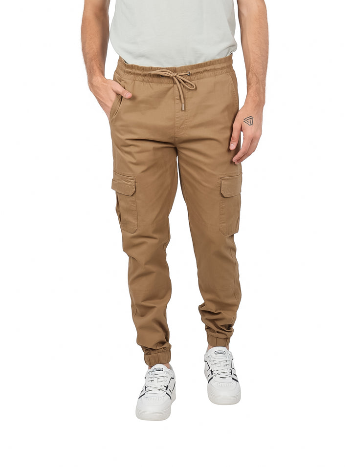 Hombre vistiendo pantalones cargo jogger color café con bolsillos laterales y cintura ajustable.