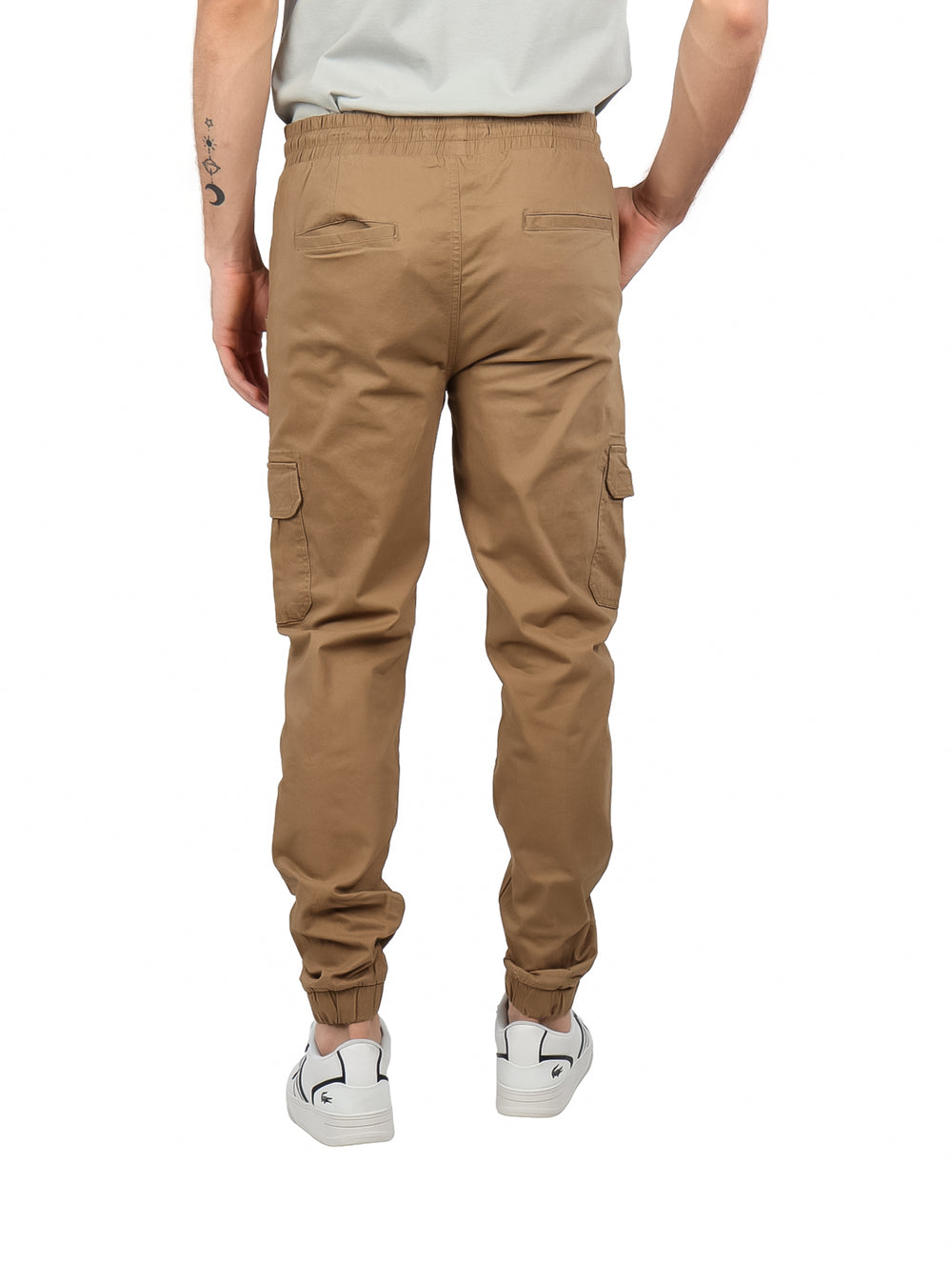Hombre vistiendo pantalones cargo jogger color café con bolsillos laterales y cintura ajustable.