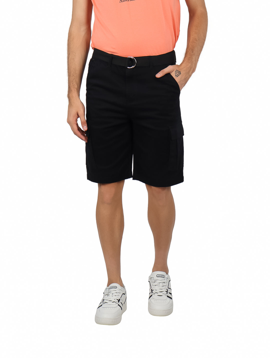 Hombre vistiendo bermudas cargo color negro con cinturón integrado y calzado blanco.