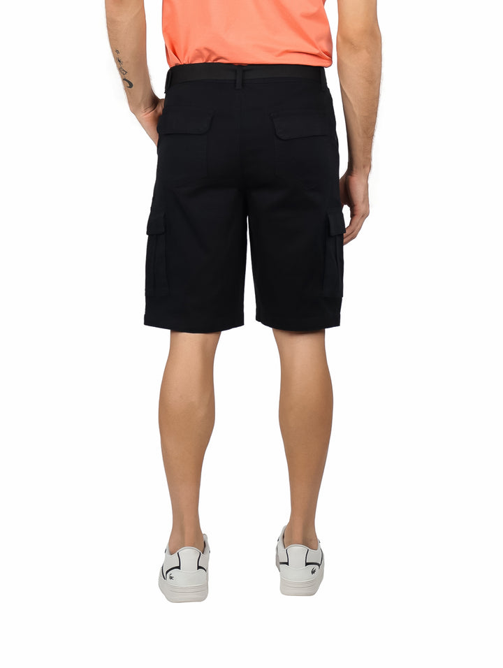 Hombre vistiendo bermudas cargo color negro con cinturón integrado y calzado blanco.